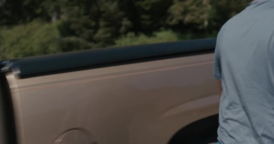 Smiling man gets out of truck and opens the truck bed cover