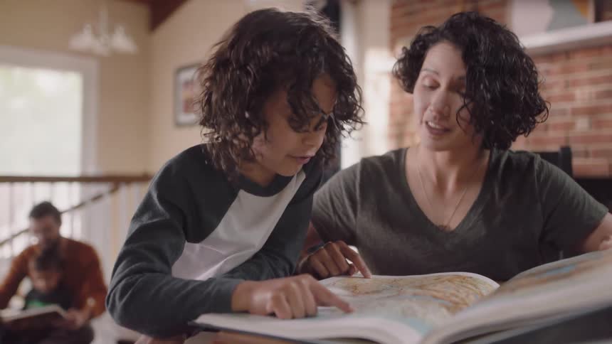Parents show their children books with maps inside