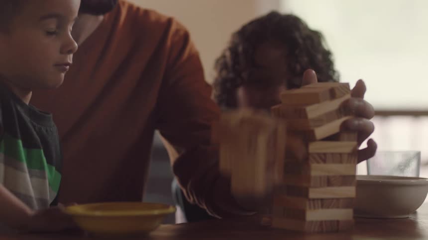 A father is playing a board game with his children