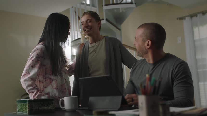 A woman walks in and greets her friends