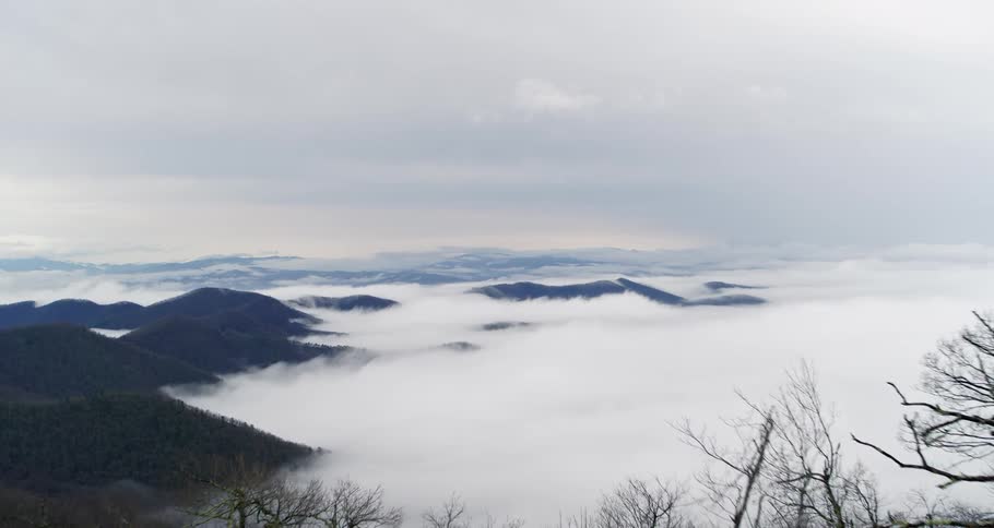 Clouds hang low below the highest peaks of a mountain range