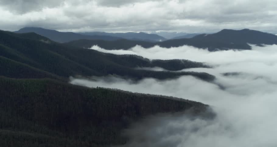 An aerial view of clouds over a hilly area