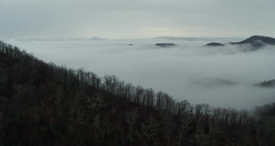 Aerial view of clouds covering the hills and slopes of a mountain