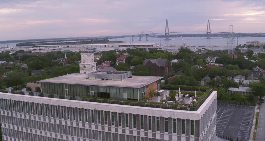 Aerial view of a waterfront city next to a bridge over a river at sunset