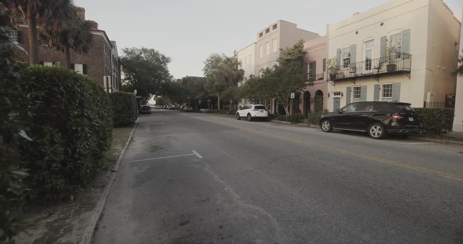 Cars sit parked on road near apartment buildings
