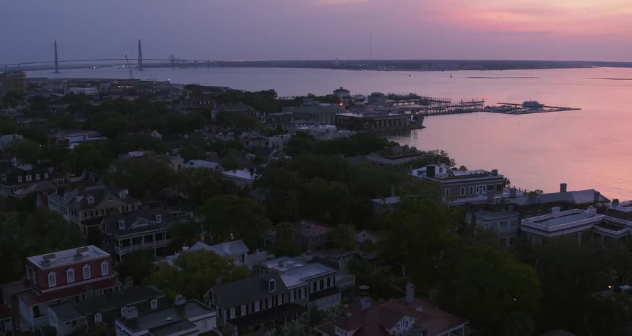 Aerial view of a small coastal town next to the ocean at sunset