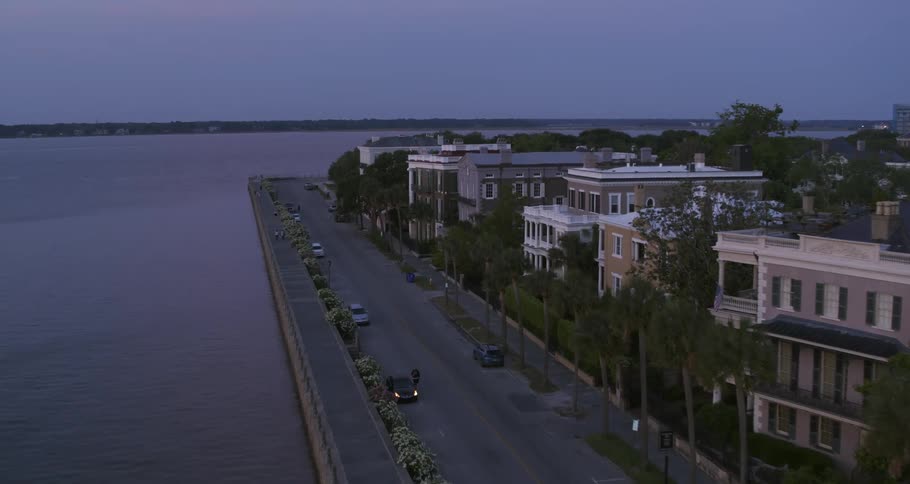 Aerial view of the street of a small waterfront neighborhood in front of a river
