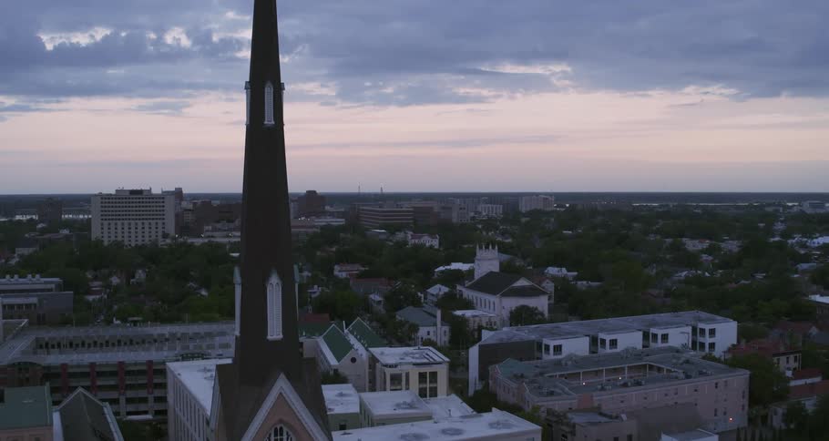 A church towers over tree lined streets in a neighborhood