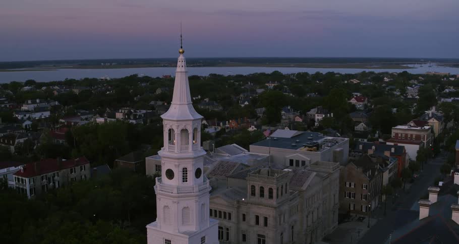 Aerial view of a white tower on a small waterfront town near a river at evening
