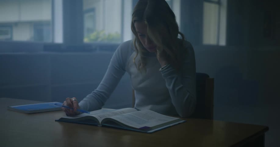 A girl is reading her textbook in class