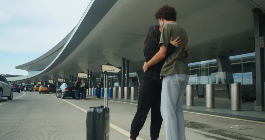 A woman hugs her friend goodbye as she heads into the airport terminal