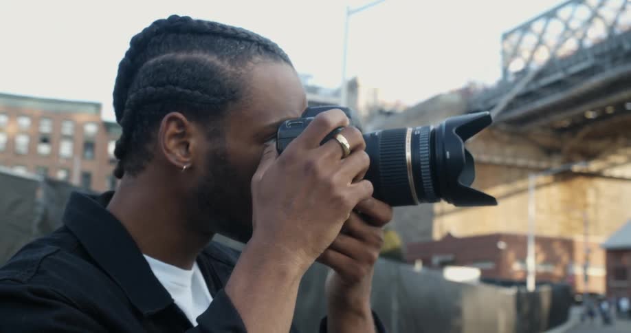 Young man takes pictures of the city streets with a camera
