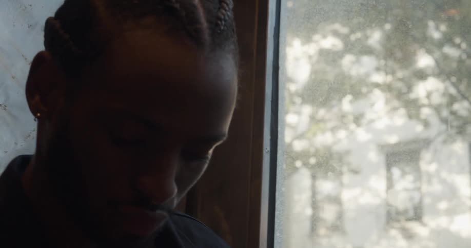 A man turns his head looking out at the neighborhood and walks away