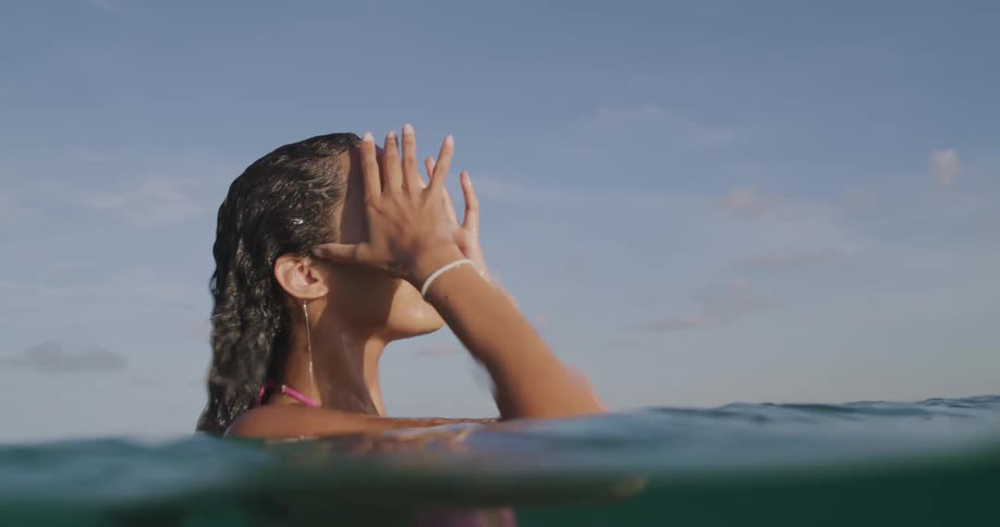 A woman rises up out of the water