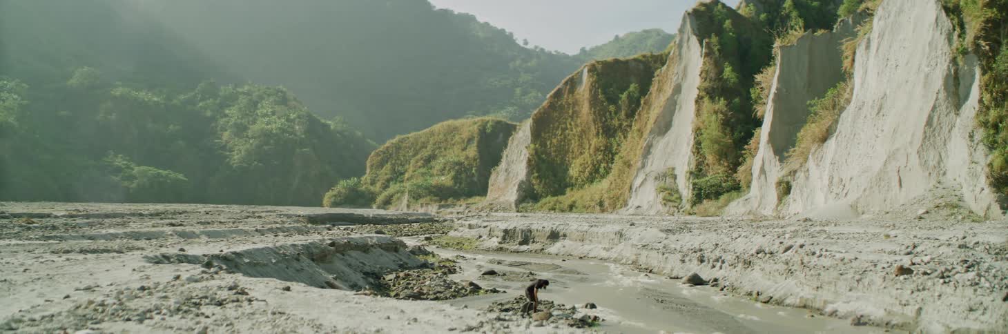 A person walking around near a river in a valley