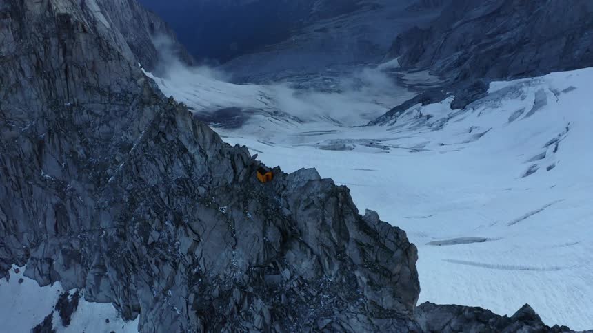 House perches on mountain ridge over snow covered valley