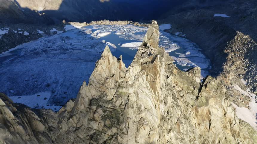Aerial view of glacial lake next to rocky mountain