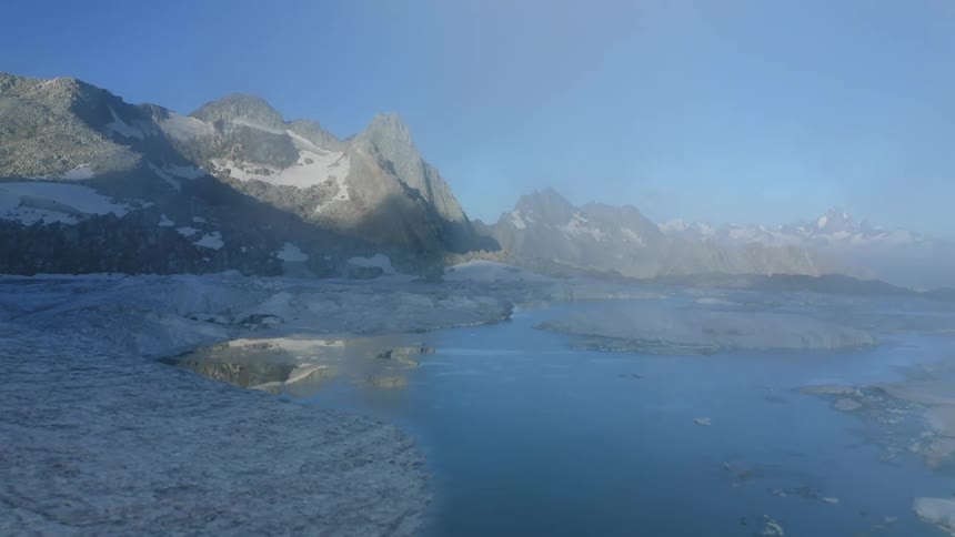 The water by the mountain is lined with icebergs