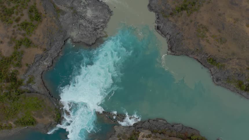 Two river converge, one tan with glacier silt and the other pristine and clear as the water mixes in yin and yang of earth forces