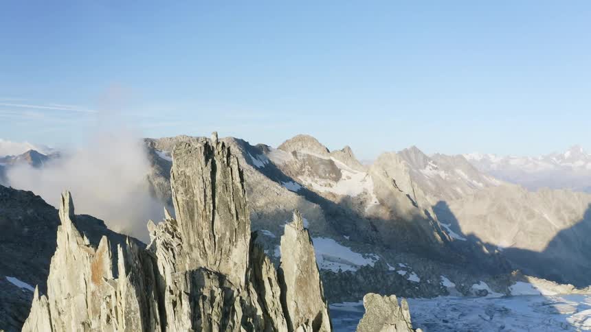 Snow covered mountains with peaks high in the sky and a mountain range in the distance