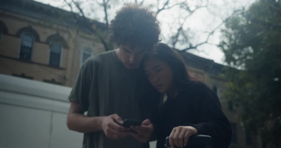 Man and woman standing near street with luggage consult mobile phone