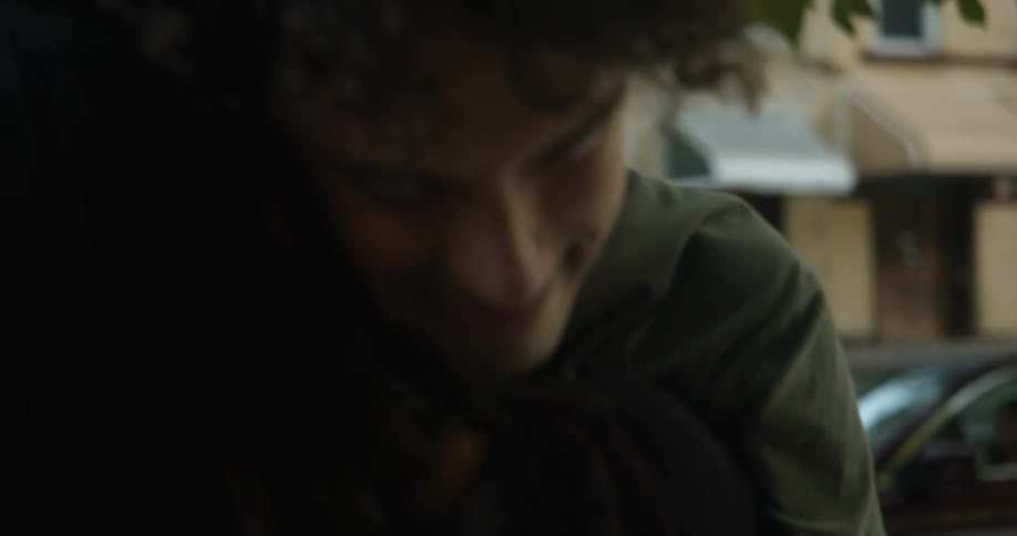 A man and woman hug on a neighborhood street