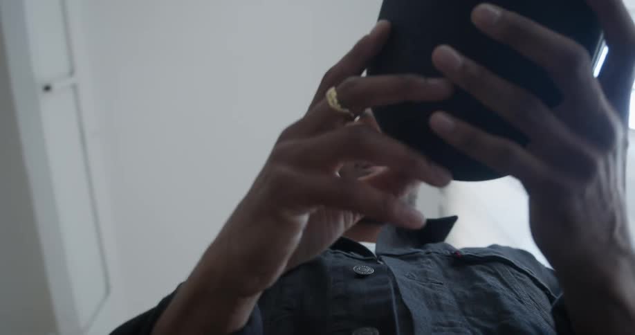 A man opens a trunk and places over the ear headphones in a compact case