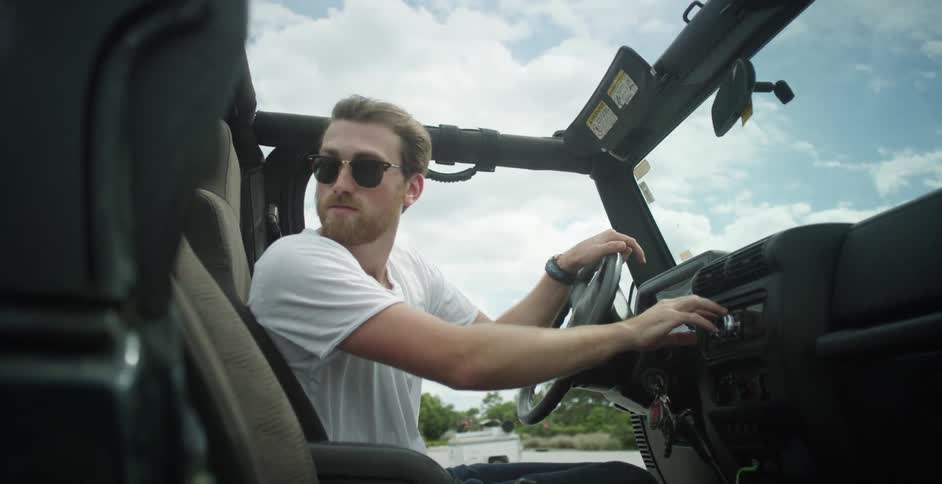 A man adjusts a radio in his jeep