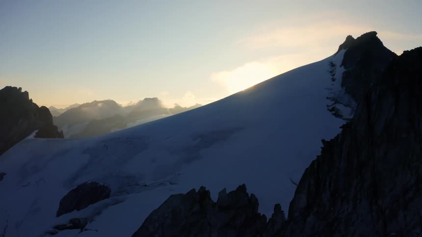 An aerial view of a mountain range with snow on it
