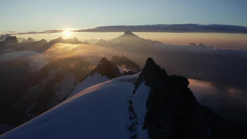 Water reflects from misty valley filling plateau surrounded by snow covered mountains