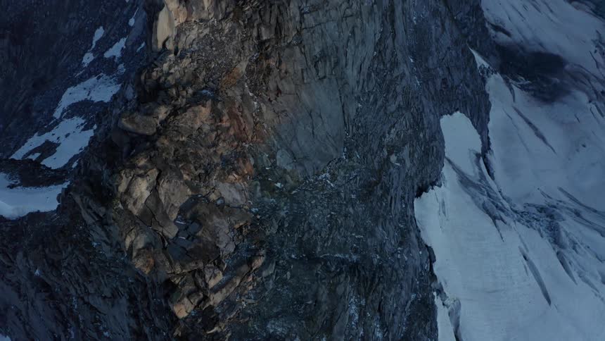 Snow covers sides of rough mountain
