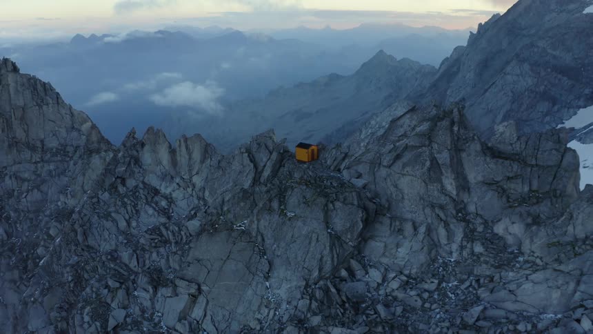 A small shelter is on the mountain top