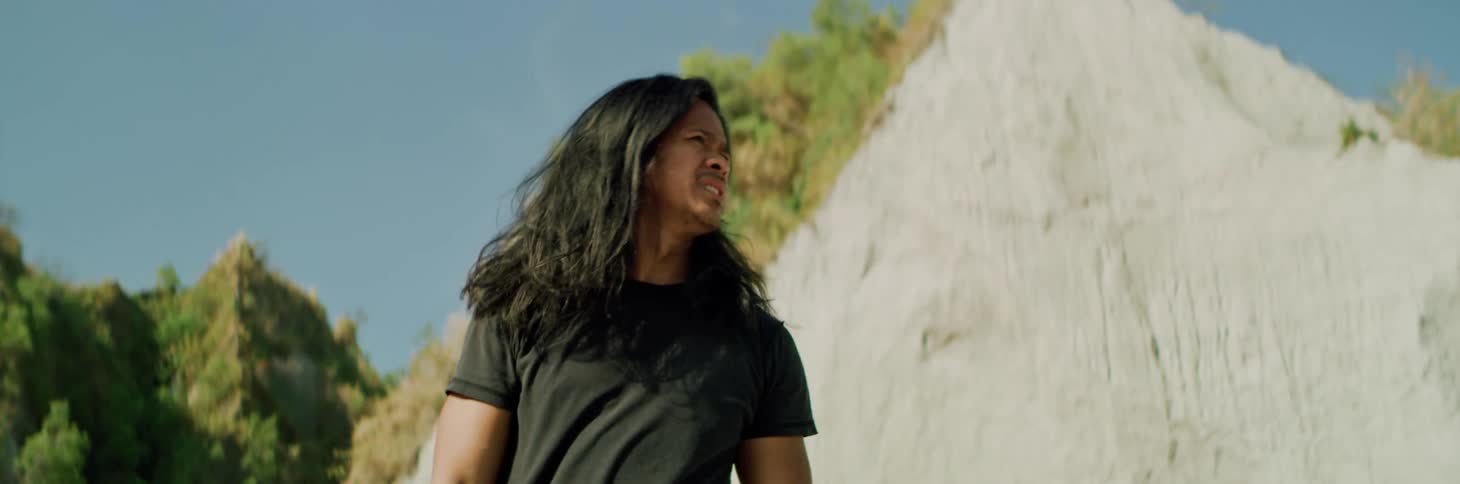 A man is searching for someone by the mountain