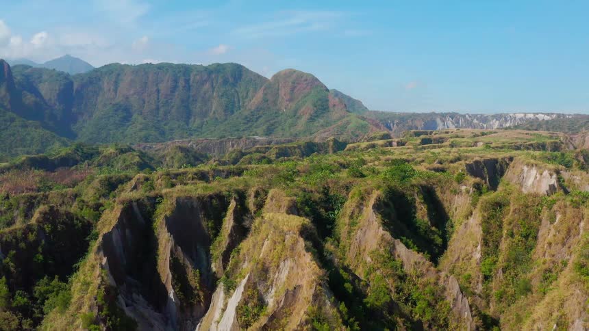 Rough vegetation covered terrain leads to mist covered mountains