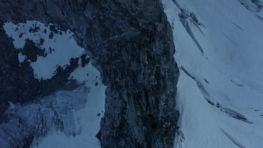 Thick ice clings to the side of a steep mountain