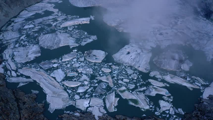 Ice floats on lake on mountain plateau on foggy day