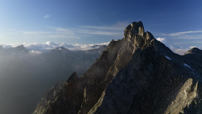 An aerial view of a jagged mountain landscape with on a sunny day