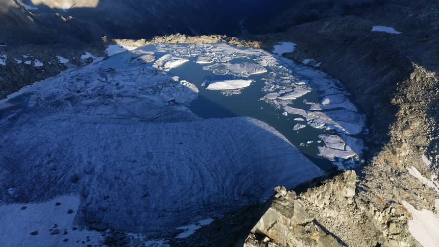 Ice floats on lake in among steep mountains