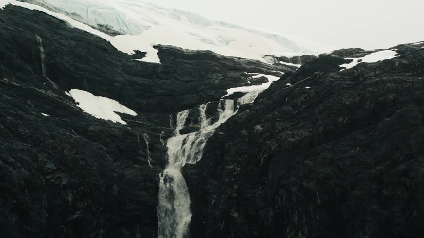 A waterfall plunges down a steep cliff