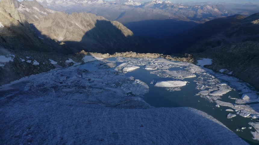 Aerial view of a frozen lake on the top of a mountain range in the morning