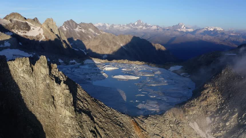 An aerial view of a mountain with a lake at the top