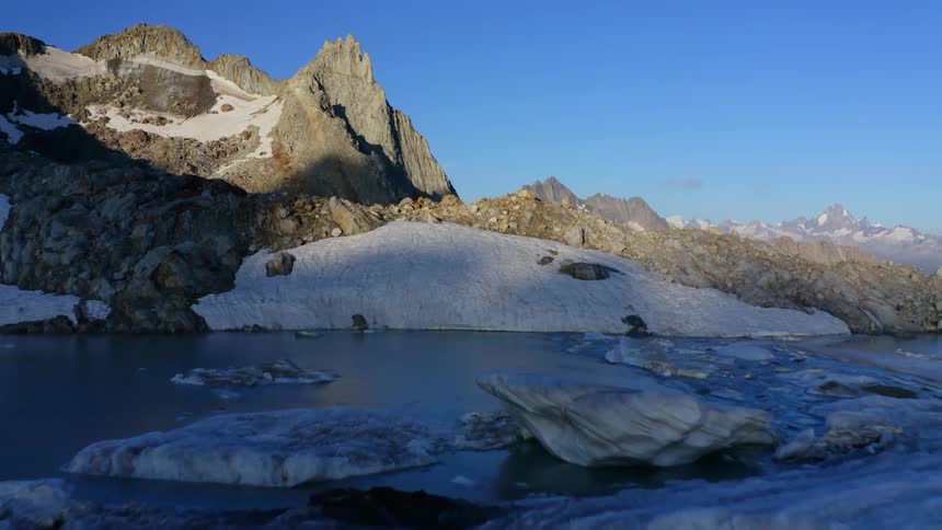 Parts of mountain sits in sunlight while water sits in shadow