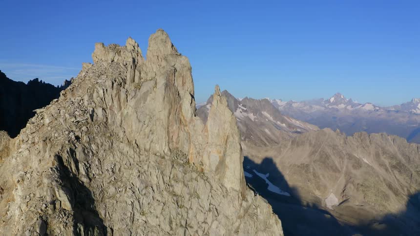 Jagged rocky mountain ridges and peaks under a bright blue sky