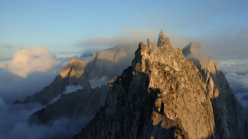 Mountain ridge peaking high in a cloudy sky