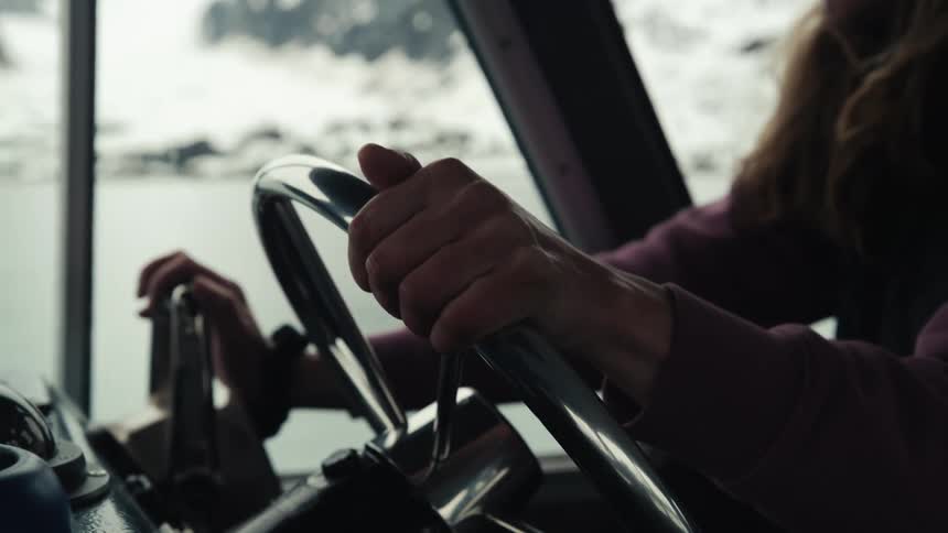 A woman is steering a vehicle past the ice