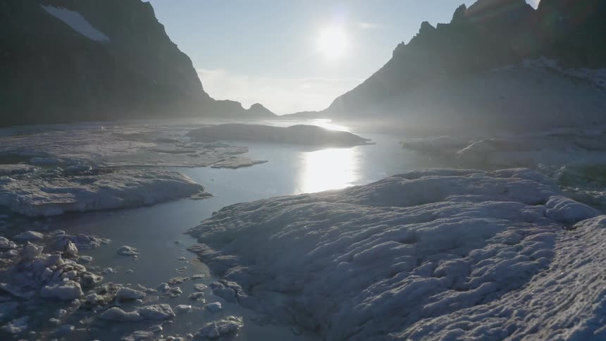 A view of a lake with ice floating in it