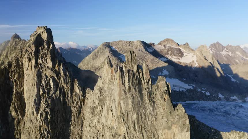 Snow covered mountains with peaks high in the sky and a mountain range in the distance