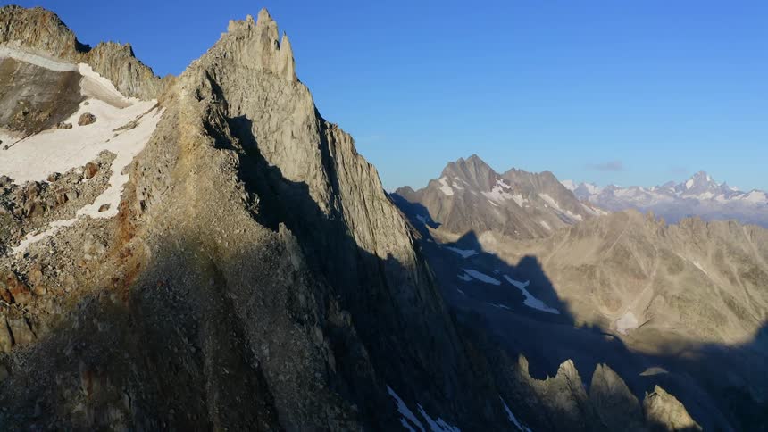 Snow dabbed mountain range sits part in shadow and part in sun