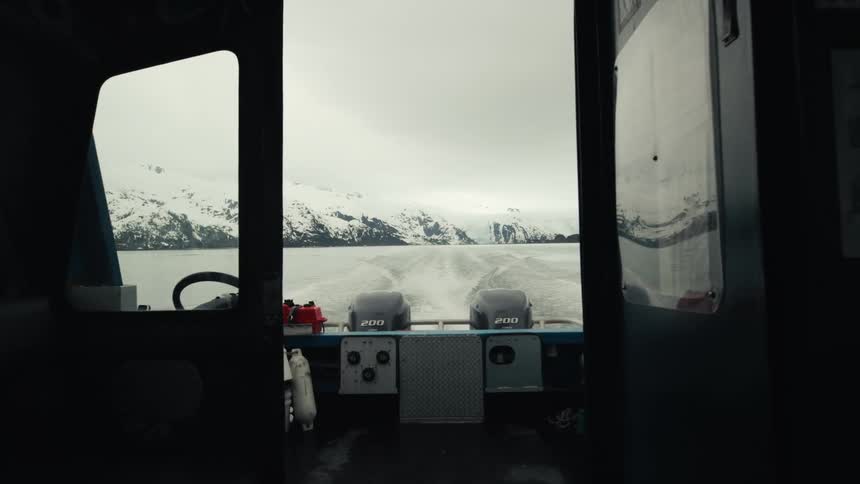 A view of snowy mountains near a lake from a boat