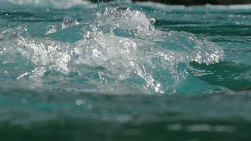 Slow motion shot of waves of pristine and clean water heaving upwards and crashing down